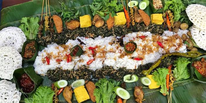 Nasi liwet hangat disajikan di atas daun pisang